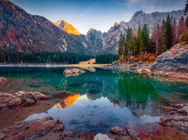 Güzel sonbahar manzarası. Fusine Gölü 'nün göz kamaştırıcı sabah manzarası. Julian Alps 'in resimli sonbahar sahnesi Mangart zirvesi arka planda, Udine ili, İtalya, Avrupa.