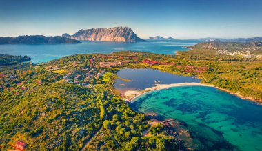 Güzel bir yaz manzarası. Arka planda Tavolara dağı olan Salina Bamba plajının uçan insansız hava aracından büyüleyici bir bahar manzarası. Sardunya Adası, İtalya, Avrupa 'nın muhteşem sabah manzarası.