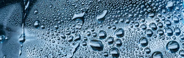 Banner of water drops on blue background. Water droplets on glass surface.