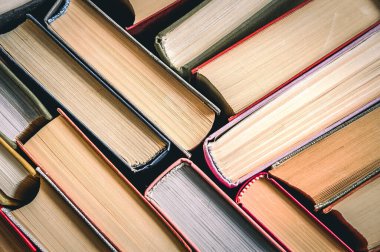 Kitaplar istiflenmiş. Kitap yığını arka plan. Bir sürü kitap yığını. Yakın plan.