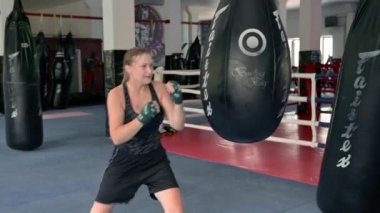 RIVNE, UKRAINE - 31 Temmuz 2021. Kum torbasında agresif ve güçlü bir kadın. Profesyonel kadın boksör spor salonunda antrenman yapıyor..