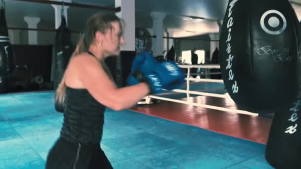 Rivne Ukraine 2021年7月31日 パンチバッグをボクシングで積極的な強い女性 プロの女性戦闘機はジムで訓練されています — ストック動画