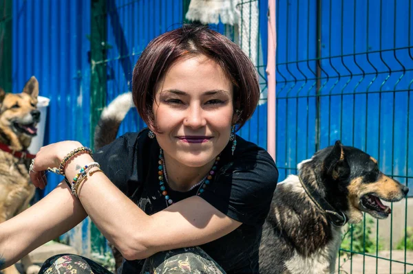 Portrait of a female volunteer at a dog shelter. Woman working in animal shelter. Smiling hipster woman