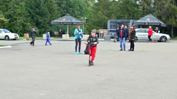 Rivne Ukraine 2022年9月29日 都市公園のスクーターの10代 少年はスクーターに乗っている 人々は歩いて 公園でリラックスしてください ライフスタイル都市レジャーレクリエーション活動 — ストック動画