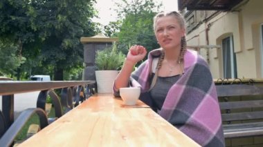 Çekici genç bir kadın kafeteryada öğle yemeği yiyor, kahve içiyor ve konuşuyor. Kahve içen ve bir kafede konuşan bir kadın.. 