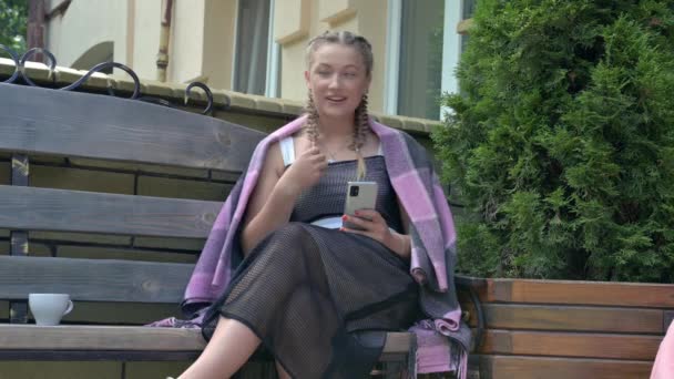 屋外のカフェテーブルに座ってコーヒーを飲みながら話すランチを持つ魅力的な若い女性 — ストック動画