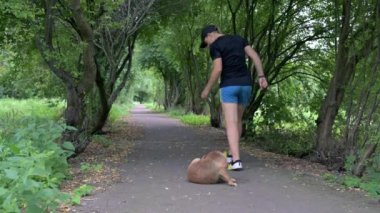 Koşu ayakkabılı bir kadın yol boyunca koşar. Şortlu ve spor ayakkabılı bir kız parkta koşuyor. Bir kız kaçıyor.. 