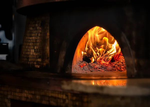 A wood fired pizza oven sits, ready with hot embers, for the chef start cooking in Kamakura, Japan.