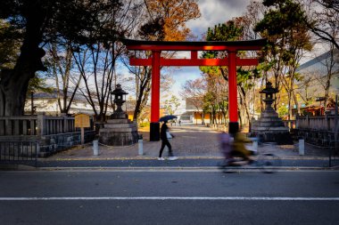 İnsanlar Japonya 'nın Kyoto kentindeki Inariokami Tapınağı' nın önündeki torii kapısından geçiyorlar..