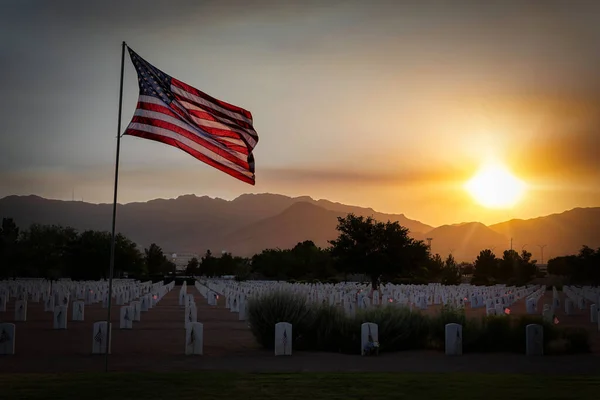 太陽がテキサス州エルパソのブリス砦国立墓地に沈むアメリカの旗波 — ストック写真