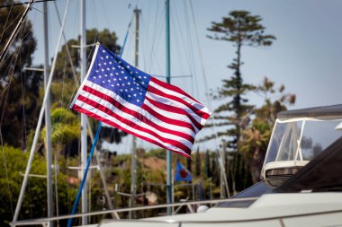 An American flag flies, blowing in the wind, aboard a sailboat at Glorietta Bay in Coronado, California.