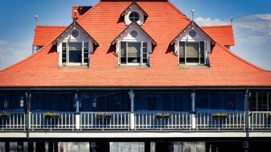 The red roof and open windows of the Coronado Boathouse, built in 1887 and now known as the Bluewater Boathouse, in Coronado, California.