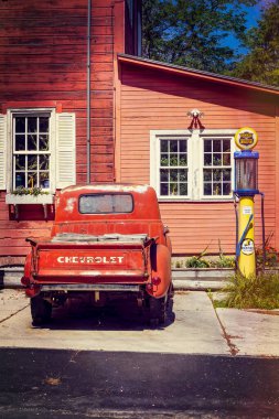 Eski bir Chevrolet kamyonet Manitowoc Rapids 'deki eski bir benzin deposunun yanında duruyor..