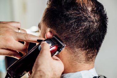 Kesme makinesinin kapanışı. Berber dükkanında saç budama işlemi.