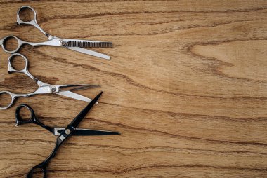 Top view of Barber scissors over wooden table. Barbershop background with copy space.