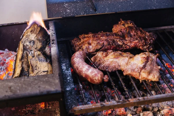 making a barbecue with a portbale grill on the balcony of his apartment. Traditional roast beef of Argentina. Asado.