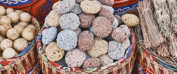 Gekleurde puimsteen voor voeten in mand als souvenir voor toeristen. Vulkanische rots met poreuze structuur. — Stockfoto
