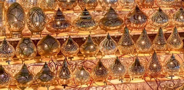 Electric luminous metal perforated lamps in oriental style as tourist souvenirs at night street market. — Stock Photo, Image