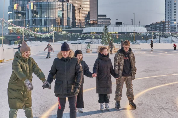 Junge Leute beim Schlittschuhlaufen auf der Eisbahn. Winterliches Unterhaltungskonzept — Stockfoto