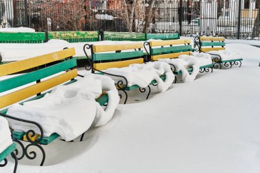 Şehir parkının yaz amfi tiyatrosunda karla kaplı ahşap banklar. Yakın plan. Kış şehri.