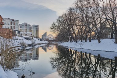 Yekaterinburg şehrinin kış şehri, güneş batarken, Rusya. Nehir, toprak seti, sirk binası. Boşluğu kopyala