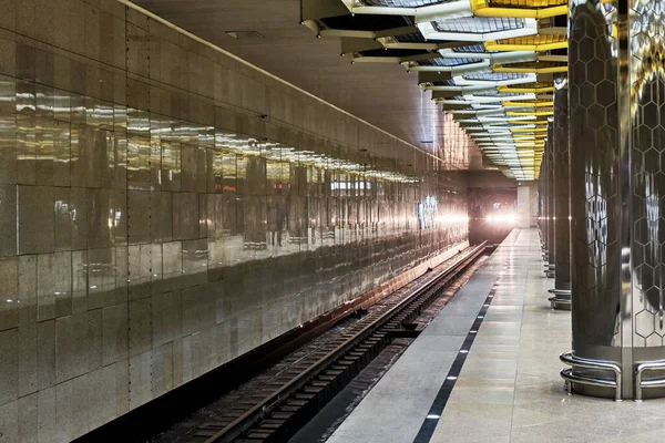Yekaterinburg, Rusya - 31 Aralık 2021: Yeraltı metro istasyonuna giden trenin parlayan farları. Taşıma kavramı
