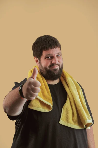Chubby man looks at the camera with a good after-sport gesture