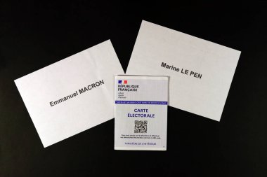 Seçmen kartı, Fransa başkanlık seçimlerinin ikinci turunda Emmanuel MacRON 'a karşı Deniz Piyadesi LE PEN' in oylarını kullanıyor. oy kabini, siyah arkaplan.