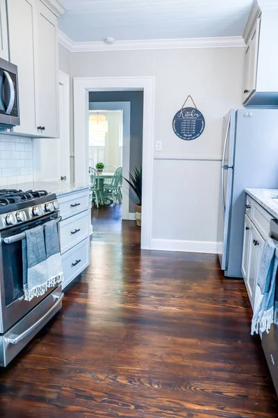 Una pequeña cocina con armarios grises y pisos de madera oscura en una casa de alquiler a corto plazo —  Fotos de Stock