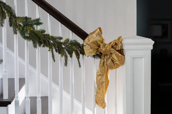 Holiday Christmas stairway stairs decor of green garland and gold glitter bows for a festive Christmas or New Years party celebration — Stockfoto