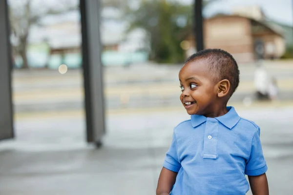 Милый годовалый малыш почти дошкольного возраста афроамериканец с большими глазами, улыбающимся и смотрящим в сторону с копировальным пространством. — стоковое фото