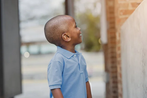 Крупный план симпатичного маленького афро-американского мальчика дошкольного возраста в голубой рубашке на улице в городе — стоковое фото