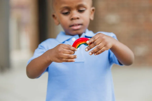 Маленький мальчик держит маленькую тканую радугу — стоковое фото
