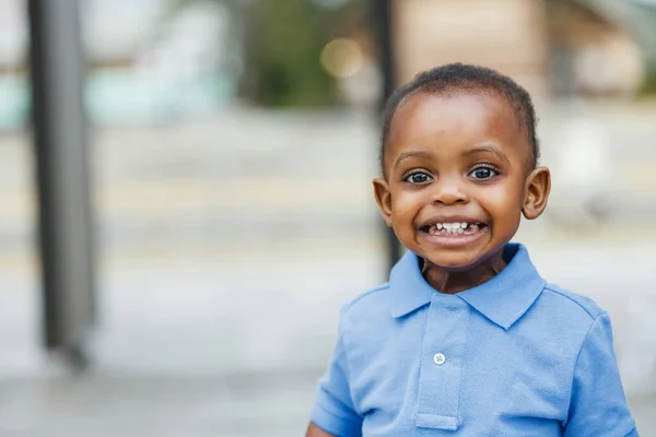 Милый годовалый малыш почти дошкольного возраста афроамериканец с большими глазами, улыбающимся и смотрящим в сторону с копировальным пространством. — стоковое фото