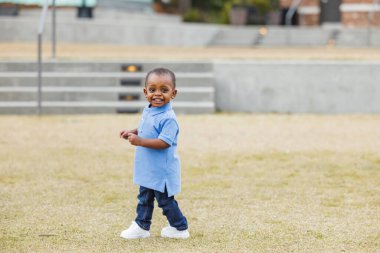 Dışarıda yürüyen sevimli bir çocuk.