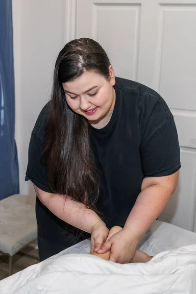 En kvinnlig budskapsterapeut som ger en kvinna fotmassage på ett lokalt spa — Stockfoto