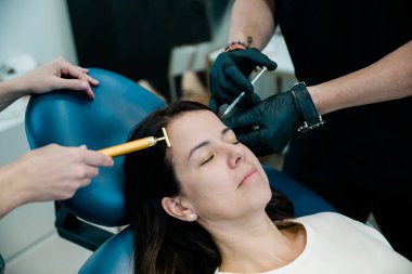 Alnında ve yüzünde botulinyum toksin ya da dolgu malzemesi olan bir kadına yakın durun.