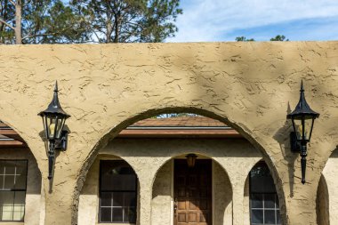 1970 'lerin kahverengi çiftlik stili villa cüruf briketi evinin ön manzarası mimari kemerler ve siyah alüminyum orijinal pencereler.