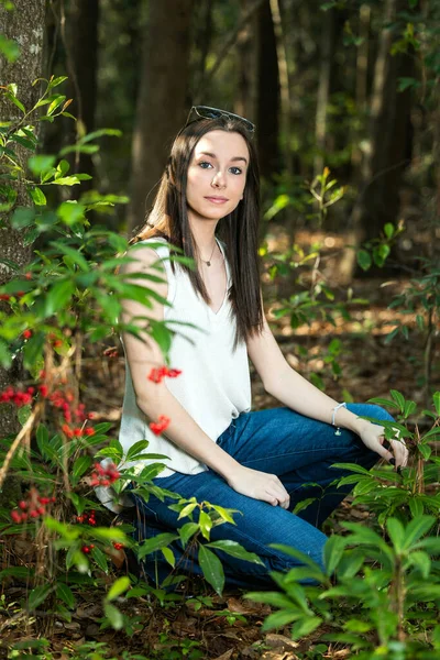 Une belle jeune fille brune sérieuse regardant loin de la caméra vers l'avenir dans une zone boisée au printemps — Photo