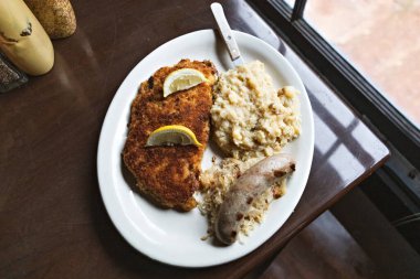 Alman domuz şnitzeli, yanında lahana salatası, sucuklu sosis ve akşam yemeği için patates püresi..