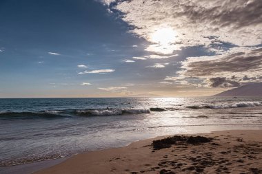 Maui Hawaii beach coastline of sand, sun, and blue water with crashing.