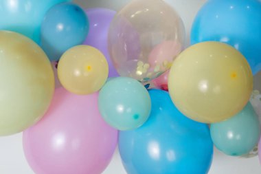A close up image of a soft pastel balloon garland against a white background.
