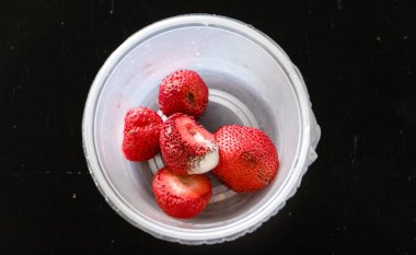 Moldy strawberries in a plastic container.