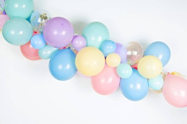 A close up image of a soft pastel balloon garland against a white background.