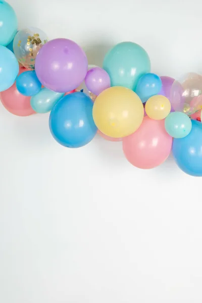 A close up image of a soft pastel balloon garland against a white background.