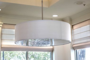 A white drum light fixture interior during the day.
