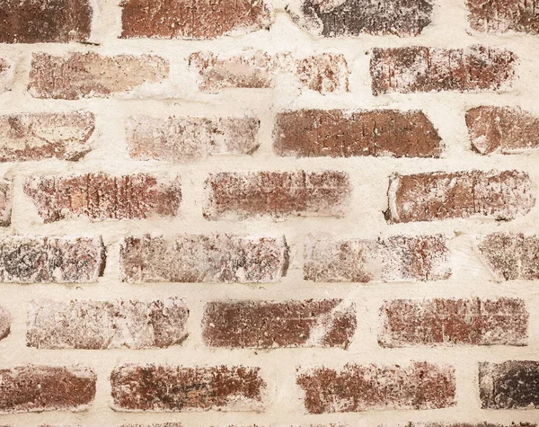 A light red brick and cream wall.