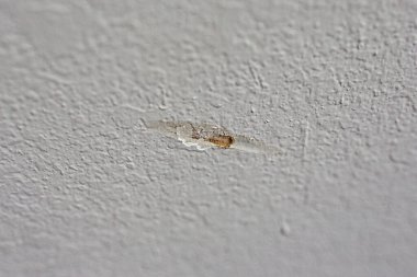 A gash in a textured greige gray beige wall in the interior of a new construction house. clipart