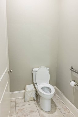 Gri duvarları olan küçük bir banyo ve yeni bir inşaatta döşemeleri olan bir tuvalet..