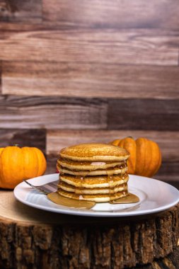 Bir yığın balkabağı krepi ve akçaağaç şurubu ile sade ahşap dilimlenmiş fotokopi alanı..